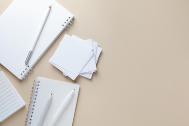 Photo of Different white stationery on beige background, flat lay. Space for text