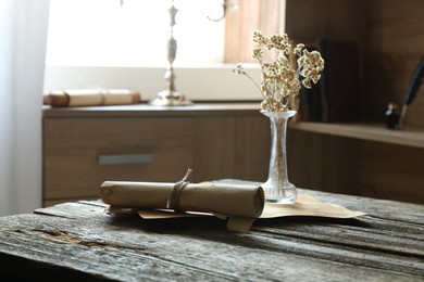 Photo of Old paper scrolls and sheets on wooden table