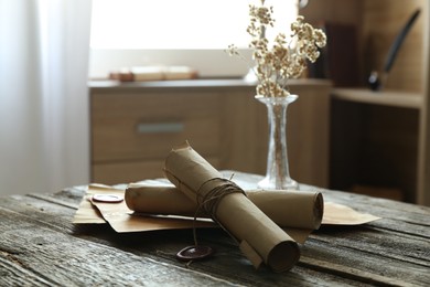 Photo of Old paper scrolls on wooden table, closeup