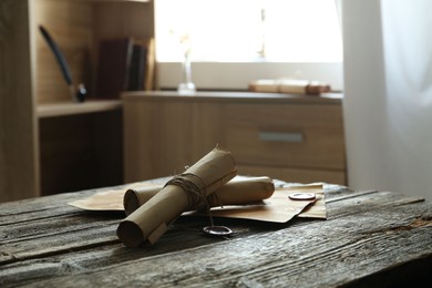 Photo of Old paper scrolls and sheets on wooden table
