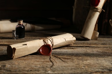 Photo of Old rolled paper scrolls on wooden table, closeup