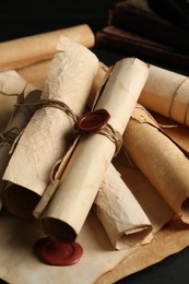 Photo of Many old rolled scrolls on black wooden table, closeup
