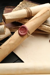 Photo of Many old rolled scrolls on black wooden table, closeup