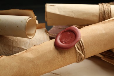 Photo of Many old rolled scrolls on black table, closeup
