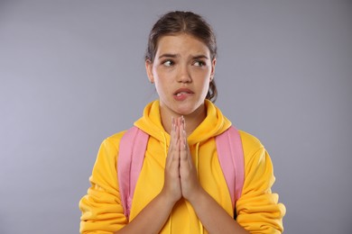 Photo of Student praying for good exam result on gray background