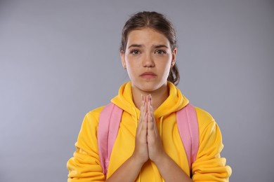 Photo of Student praying for good exam result on gray background