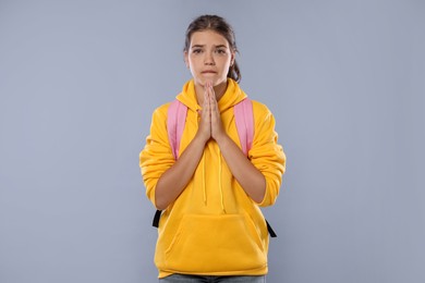 Photo of Student praying for good exam result on gray background