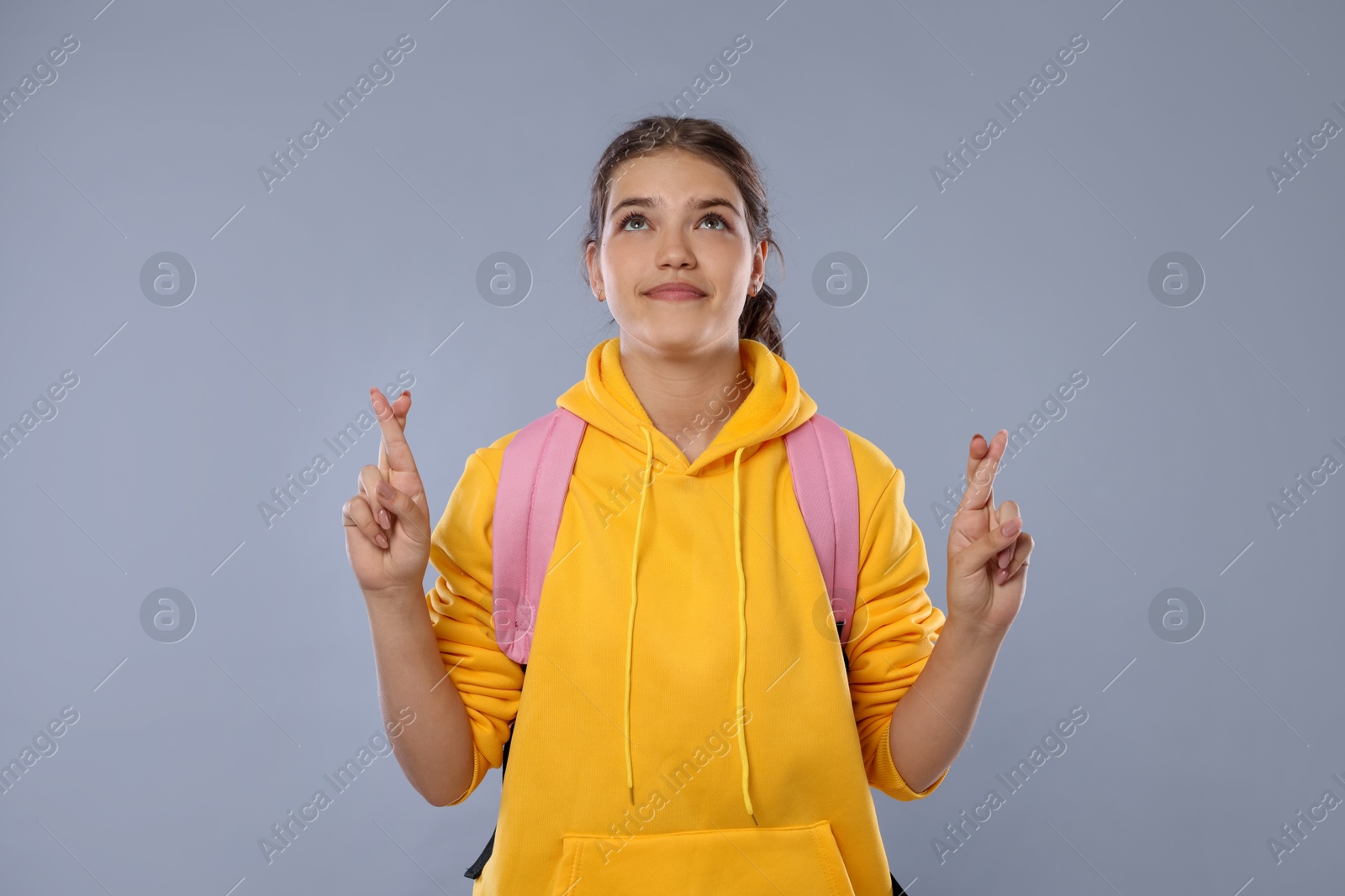 Student crossing fingers on gray background. Hope for good exam result Photo of Student crossing fingers on gray background. Hope for good exam result