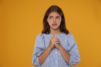 Photo of Student praying for good exam result on orange background