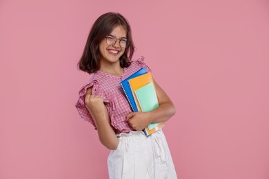 Photo of Student feeling happy about her good exam result on pink background
