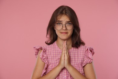 Photo of Student praying for good exam result on pink background