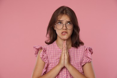 Photo of Student praying for good exam result on pink background