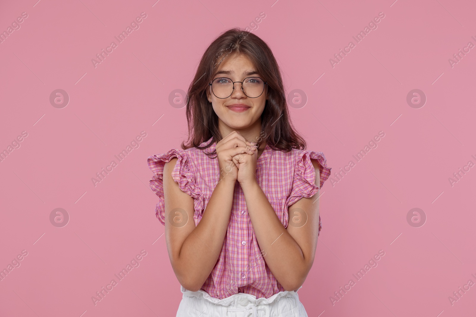 Student praying for good exam result on pink background Photo of Student praying for good exam result on pink background