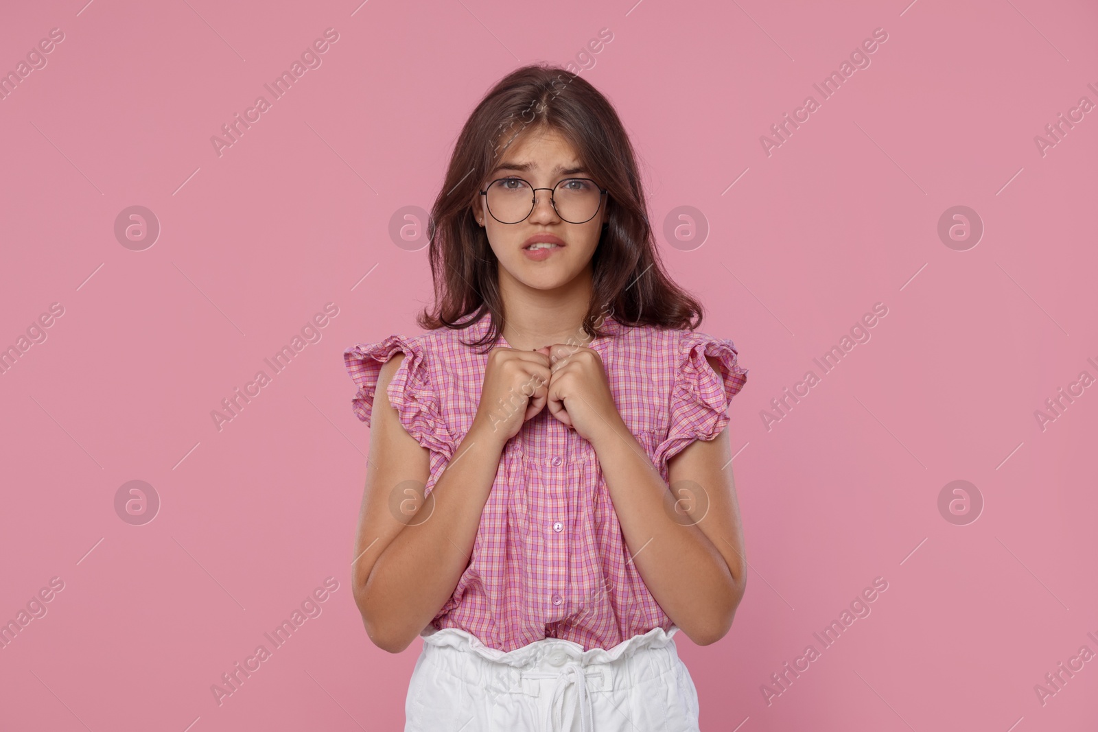 Student praying for good exam result on pink background Photo of Student praying for good exam result on pink background