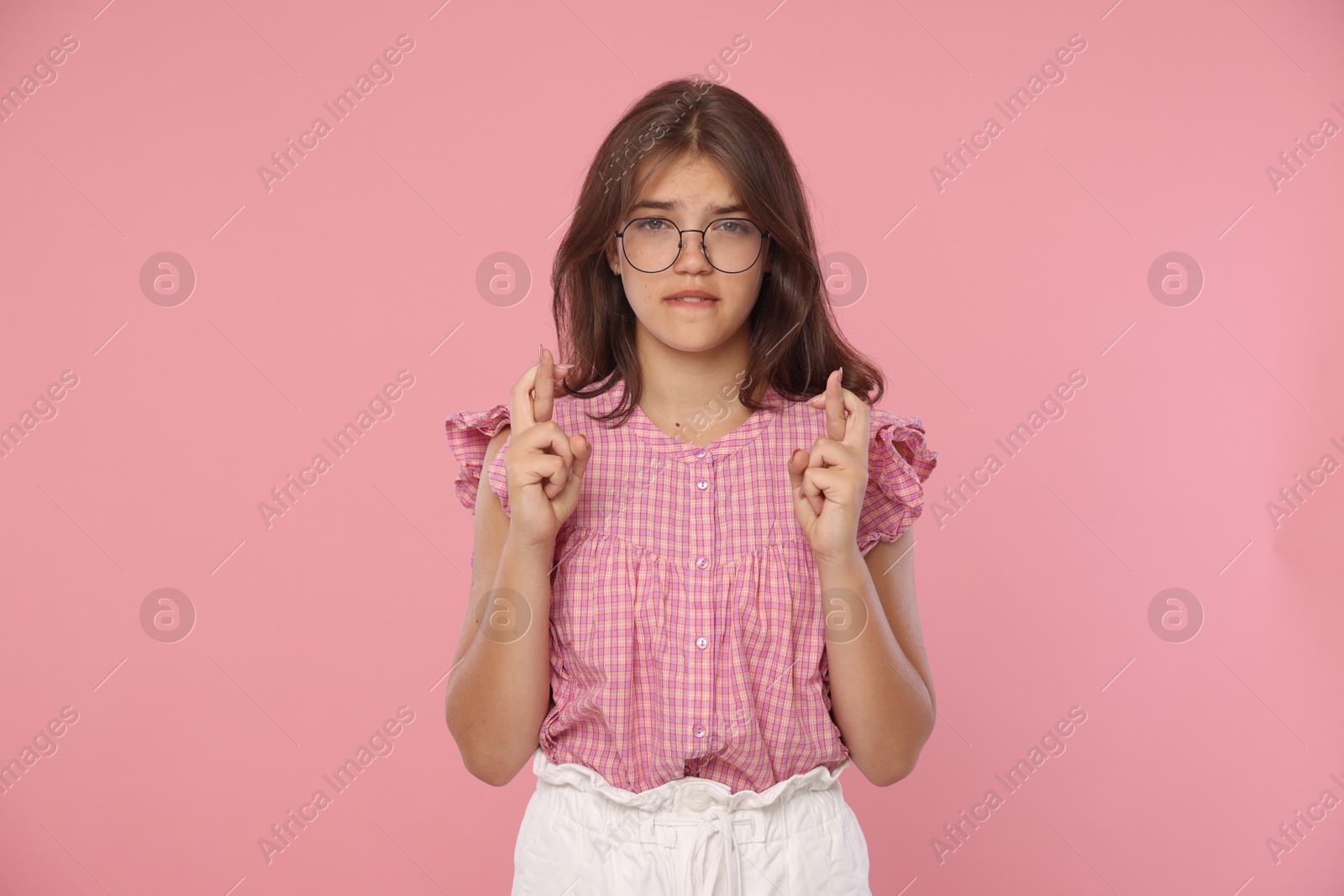 Student crossing fingers on pink background. Hope for good exam result Photo of Student crossing fingers on pink background. Hope for good exam result