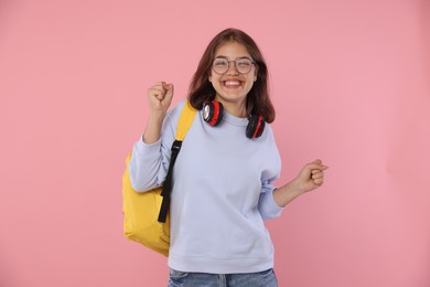Photo of Student feeling happy about her good exam result on pink background