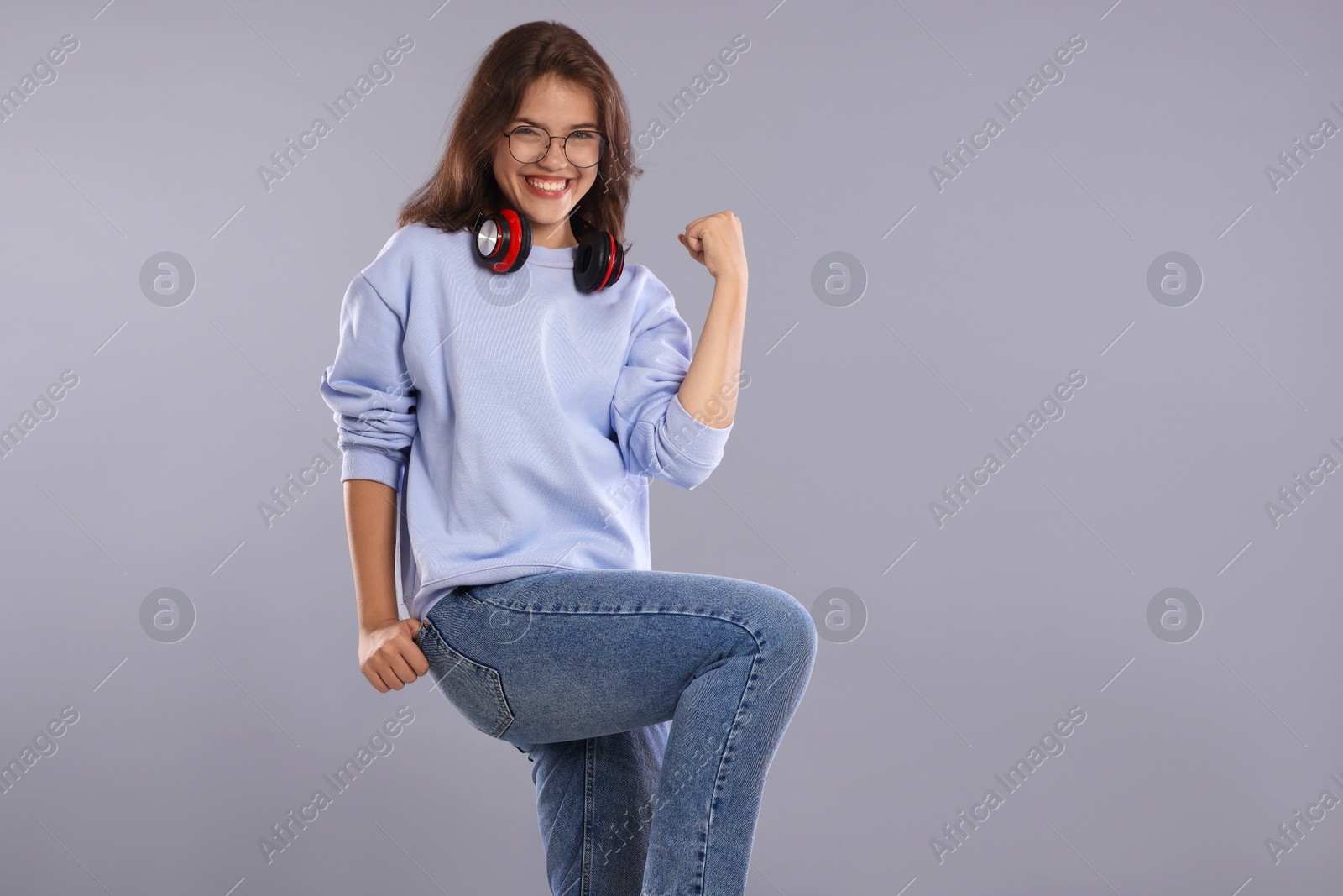 Student feeling happy about her good exam result on gray background Photo of Student feeling happy about her good exam result on gray background