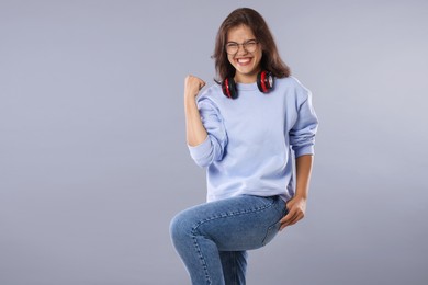 Photo of Student feeling happy about her good exam result on gray background