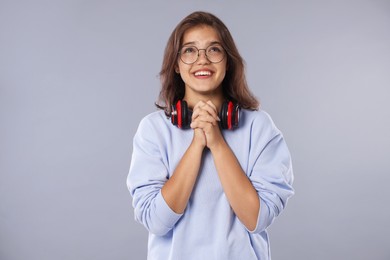 Photo of Student praying for good exam result on gray background