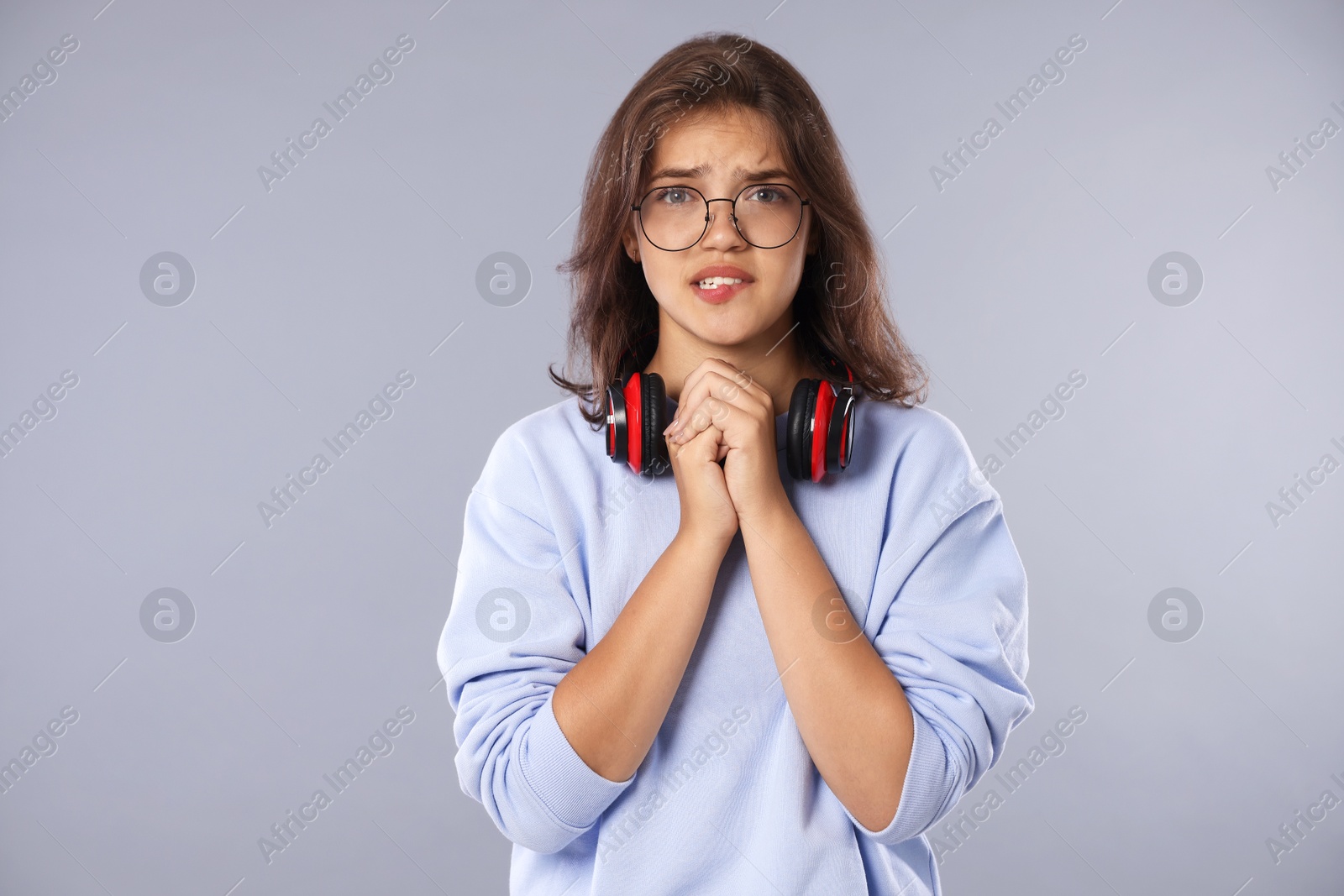 Student praying for good exam result on gray background Photo of Student praying for good exam result on gray background