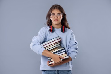 Photo of Student with stack of books worried about her exam result on gray background