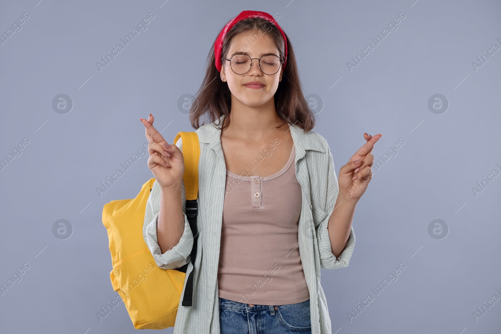 Student crossing fingers on gray background. Hope for good exam result Photo of Student crossing fingers on gray background. Hope for good exam result