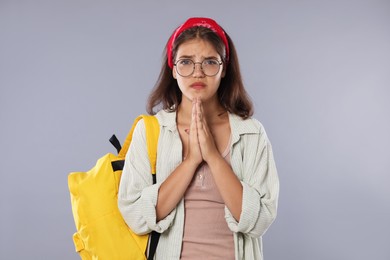 Photo of Student praying for good exam result on gray background
