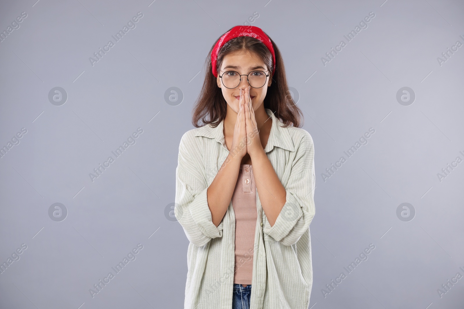 Student praying for good exam result on gray background Photo of Student praying for good exam result on gray background