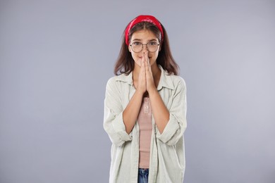 Photo of Student praying for good exam result on gray background