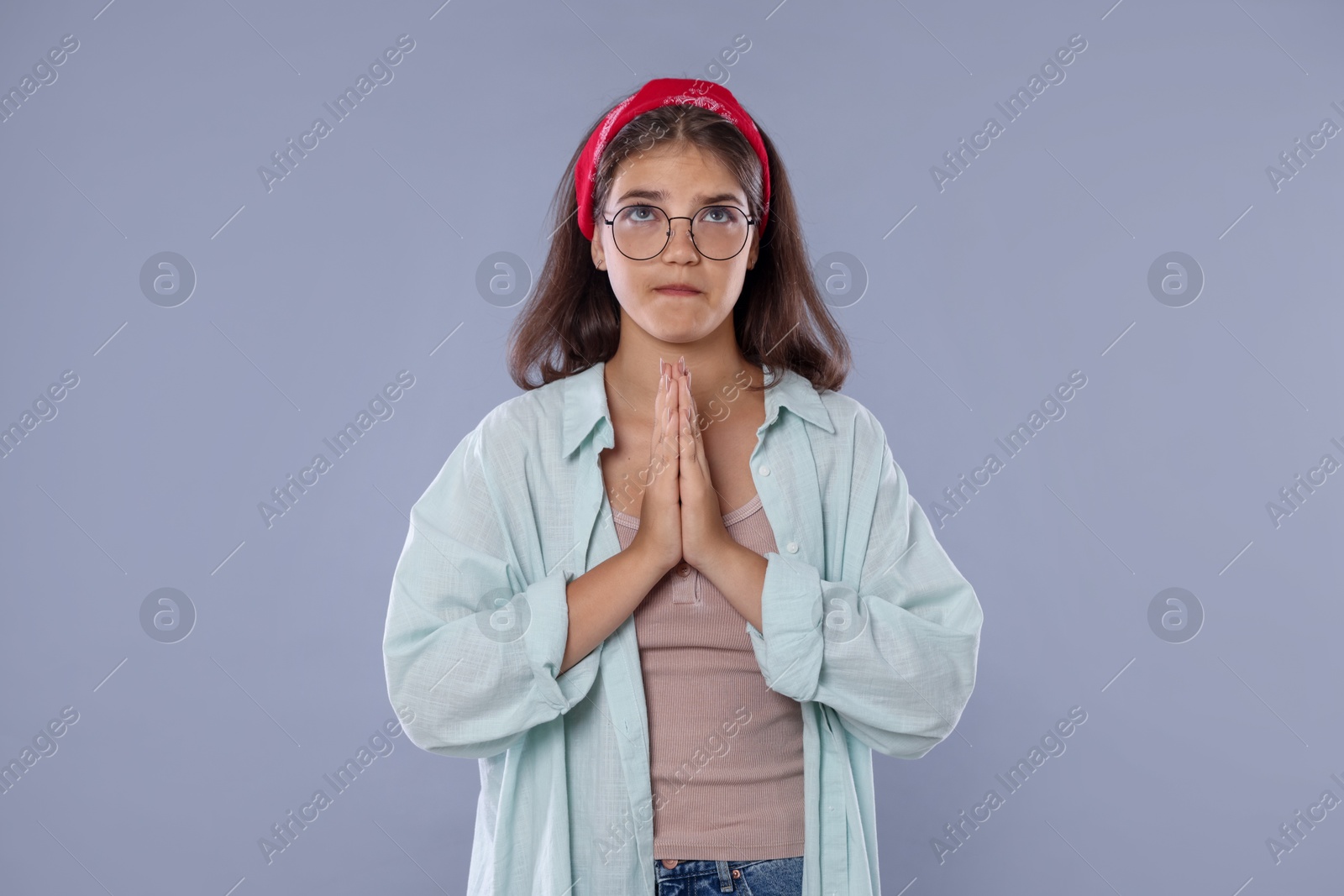 Student praying for good exam result on gray background Photo of Student praying for good exam result on gray background