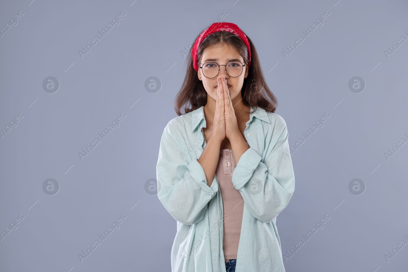 Student praying for good exam result on gray background Photo of Student praying for good exam result on gray background