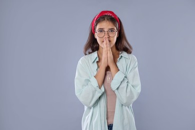 Photo of Student praying for good exam result on gray background