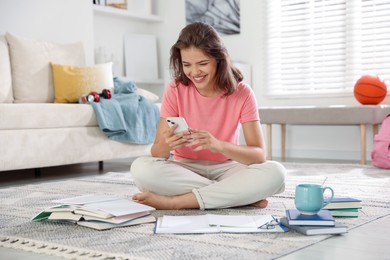Photo of Student with smartphone feeling happy about her good exam result at home