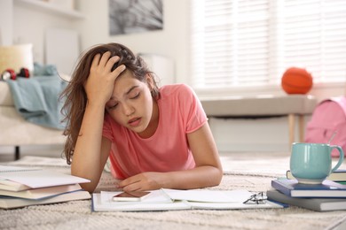 Photo of Tired student preparing for exam at home