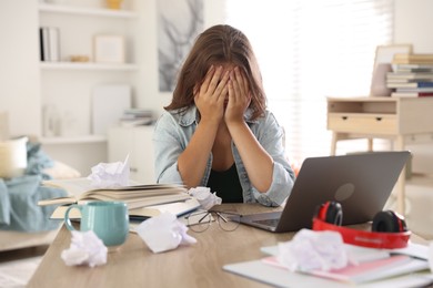 Photo of Tired student preparing for exam at table indoors