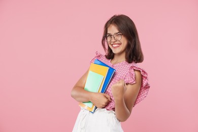 Photo of Student feeling happy about her good exam result on pink background