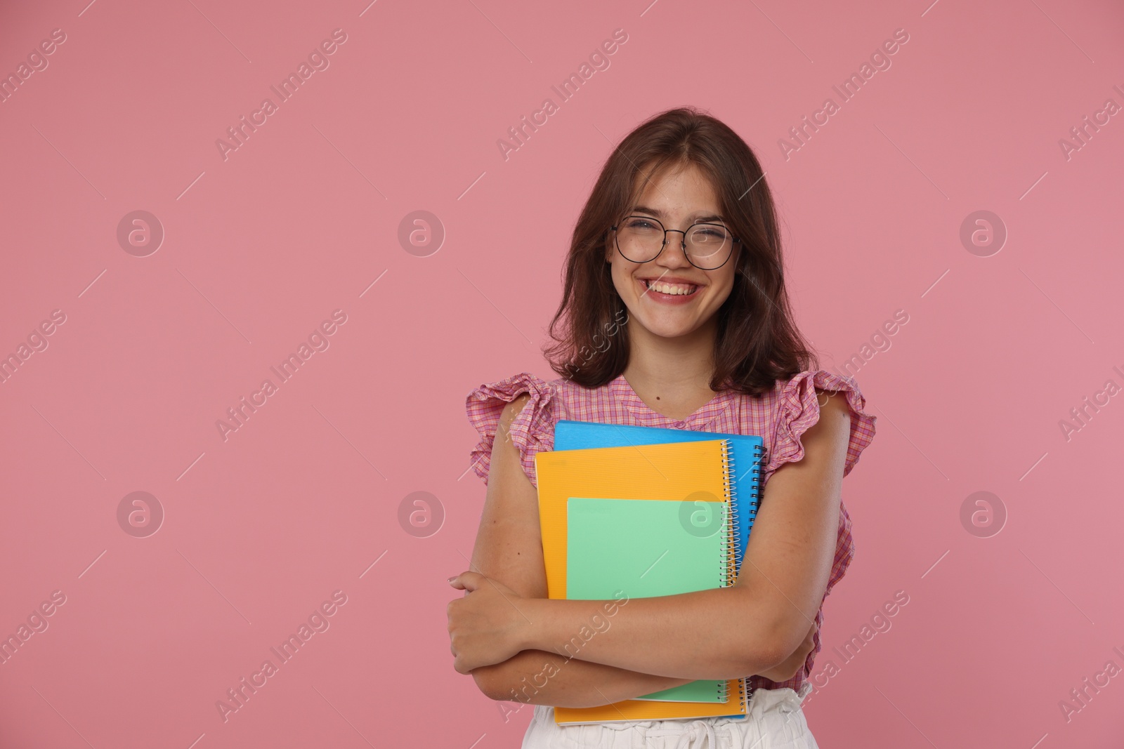 Student feeling happy about her good exam result on pink background Photo of Student feeling happy about her good exam result on pink background