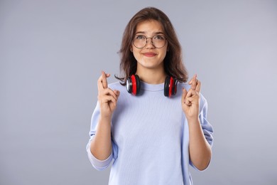 Photo of Student crossing fingers on gray background. Hope for good exam result