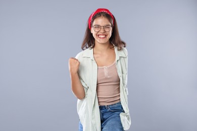 Photo of Student feeling happy about her good exam result on gray background