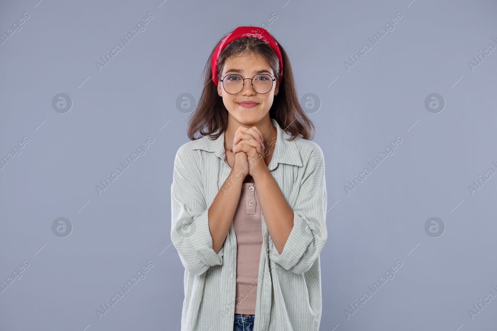 Student praying for good exam result on gray background Photo of Student praying for good exam result on gray background