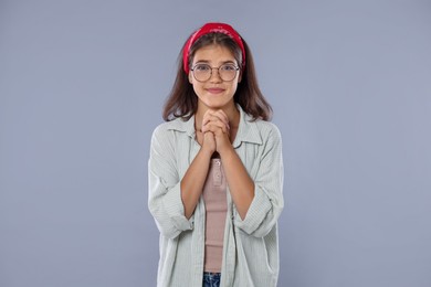 Photo of Student praying for good exam result on gray background