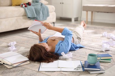 Photo of Student preparing for exam on rug indoors