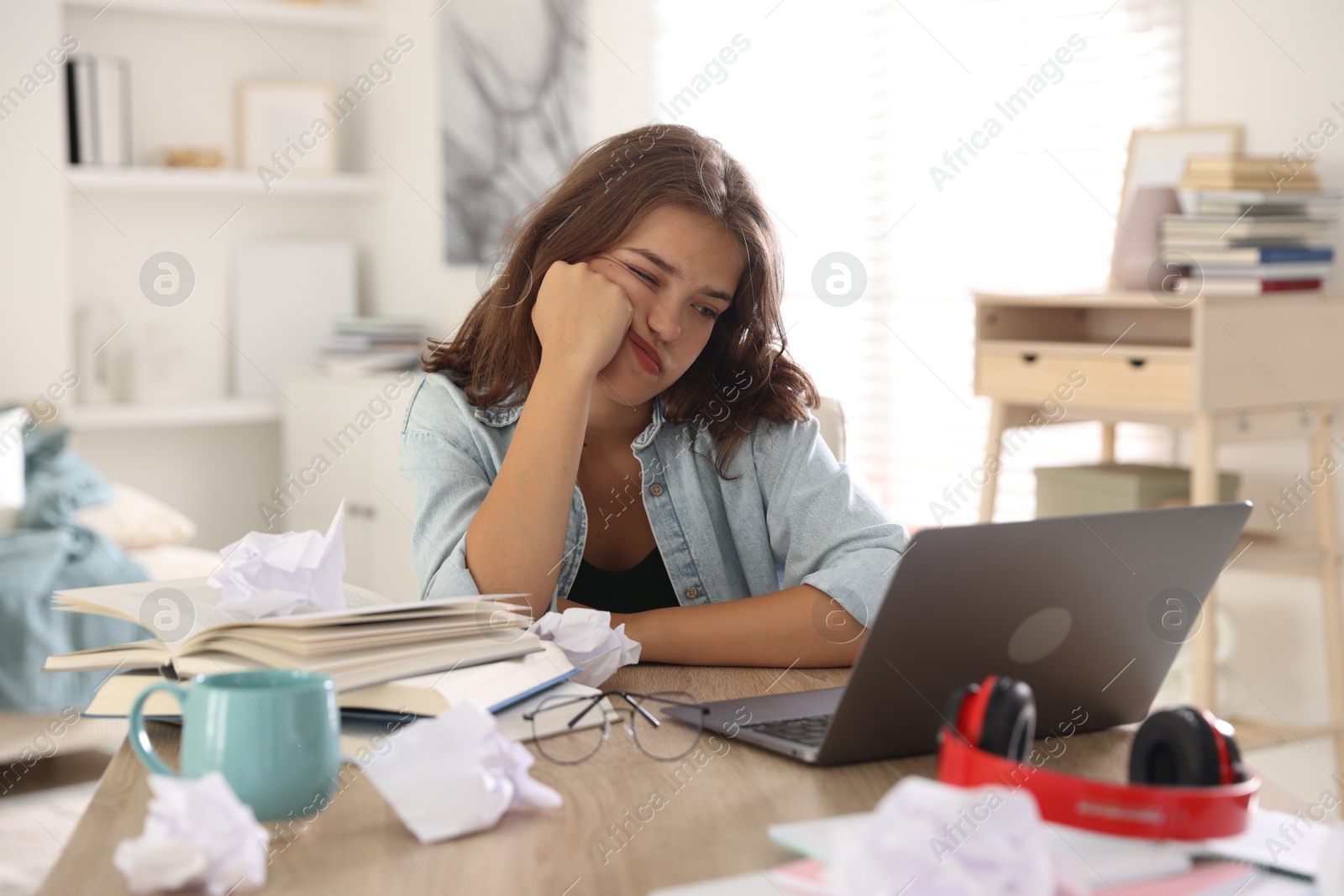 Tired student preparing for exam at table indoors Photo of Tired student preparing for exam at table indoors