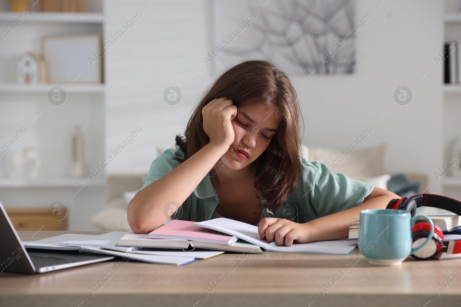 Tired student preparing for exam at table indoors Photo of Tired student preparing for exam at table indoors