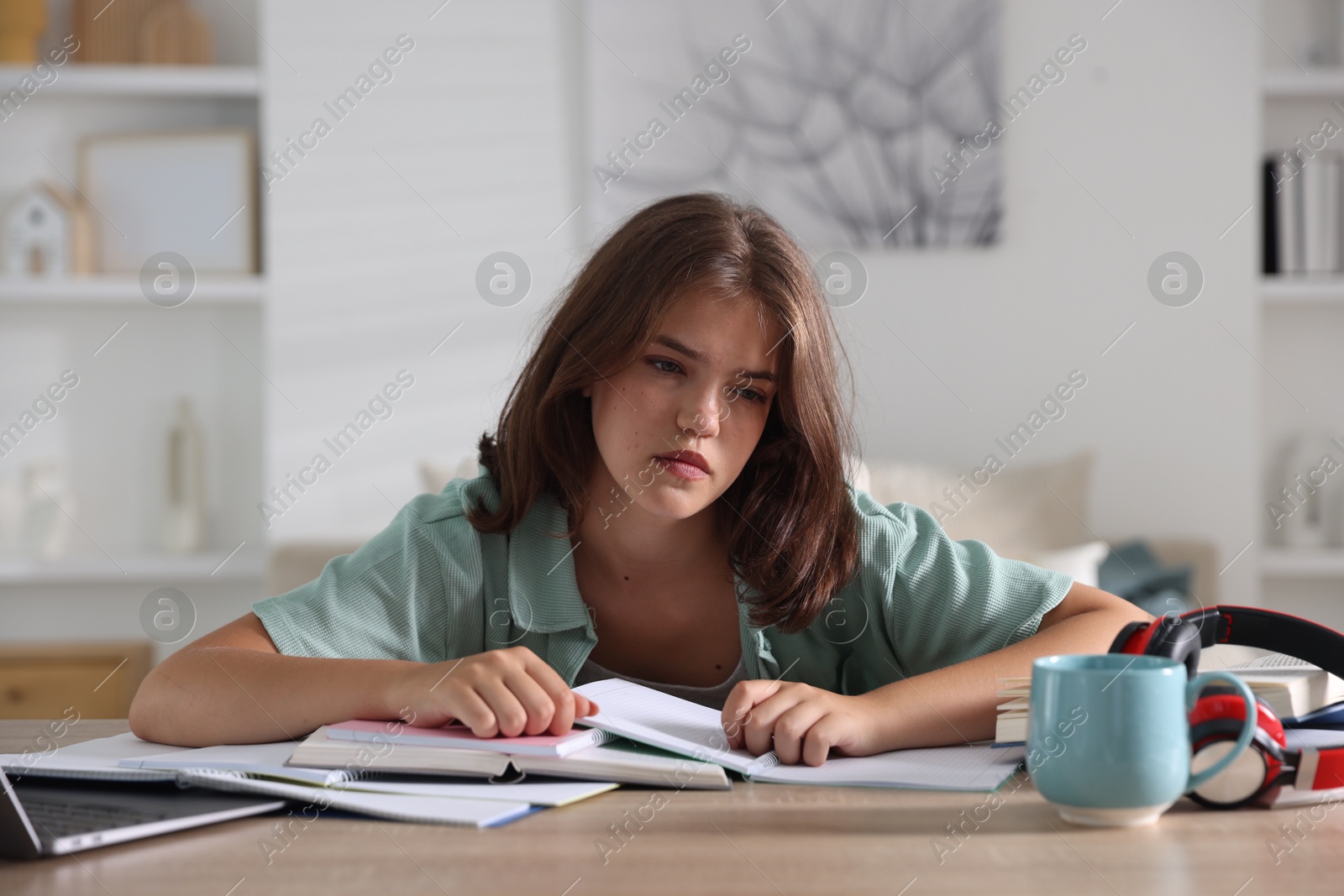 Tired student preparing for exam at table indoors Photo of Tired student preparing for exam at table indoors