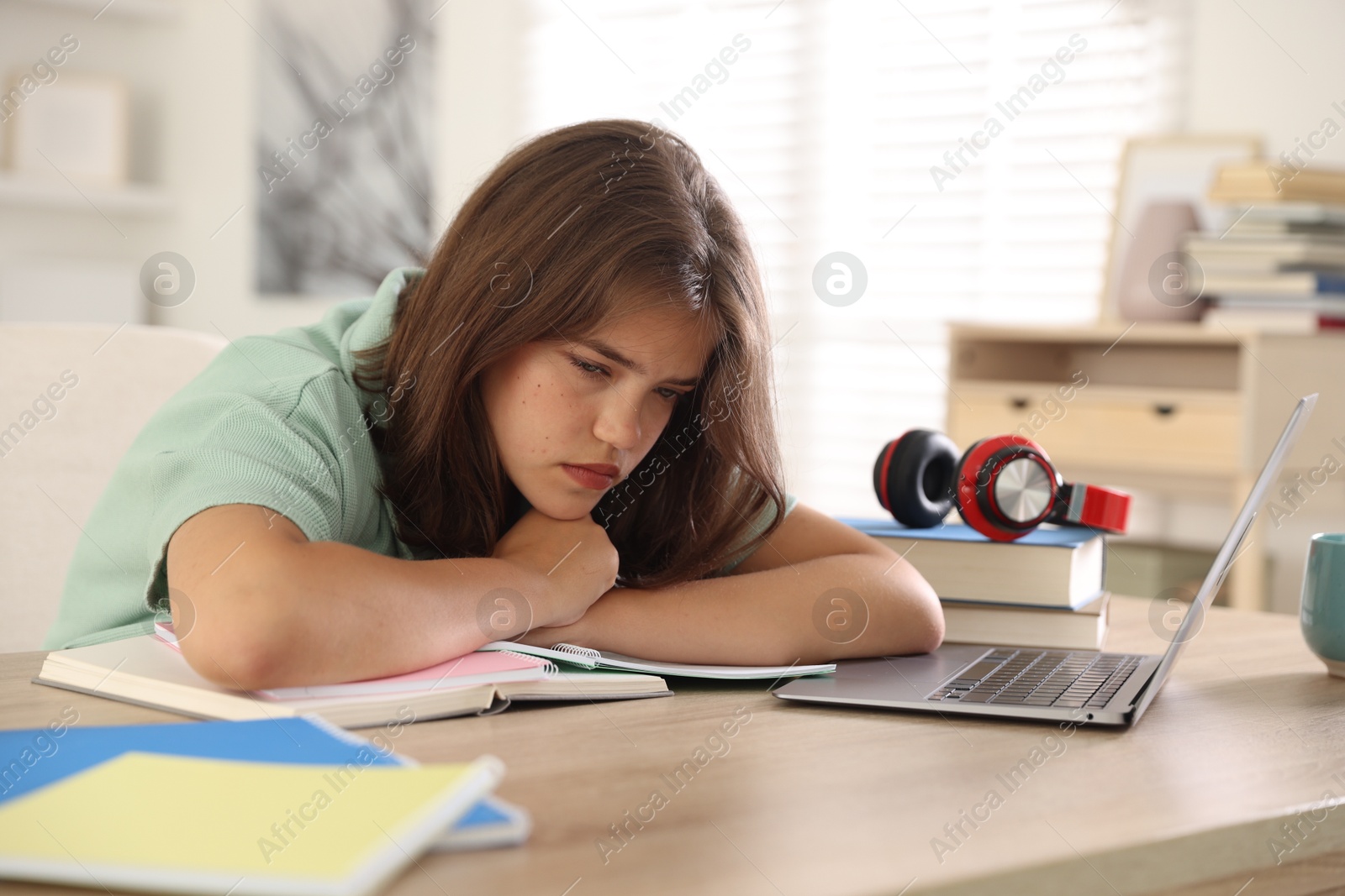Tired student preparing for exam at table indoors Photo of Tired student preparing for exam at table indoors