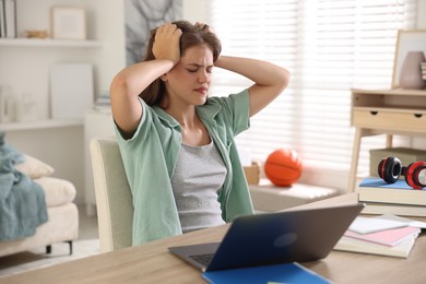 Photo of Stressed student preparing for exam at home