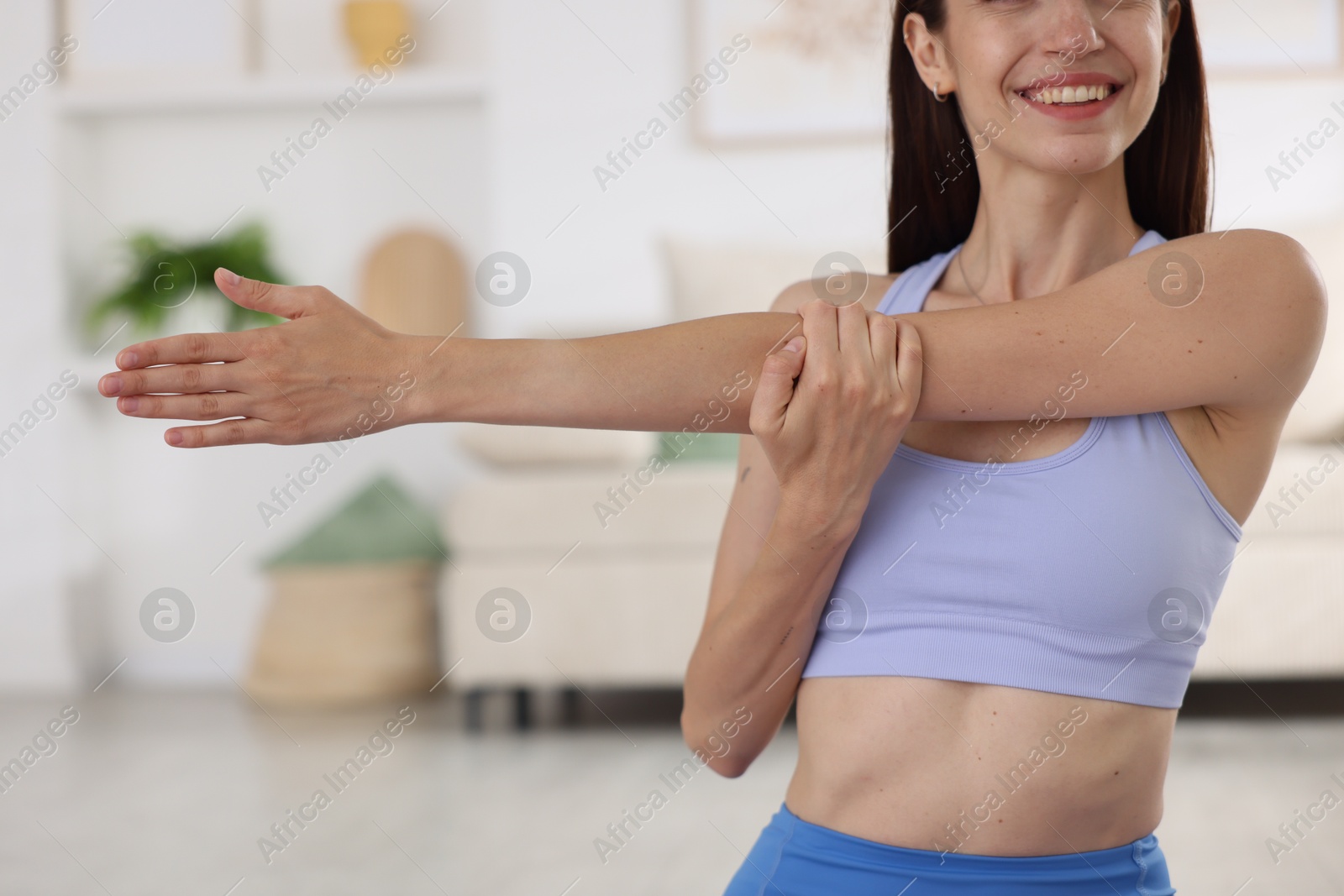 Smiling woman in sportswear stretching at home, closeup Photo of Smiling woman in sportswear stretching at home, closeup