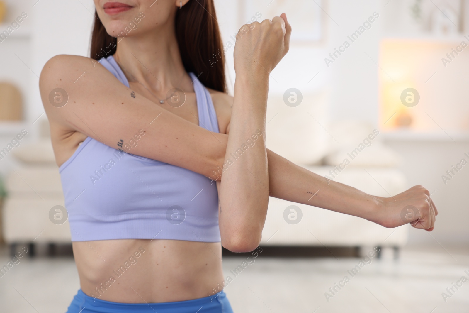Woman in sportswear stretching at home, closeup Photo of Woman in sportswear stretching at home, closeup