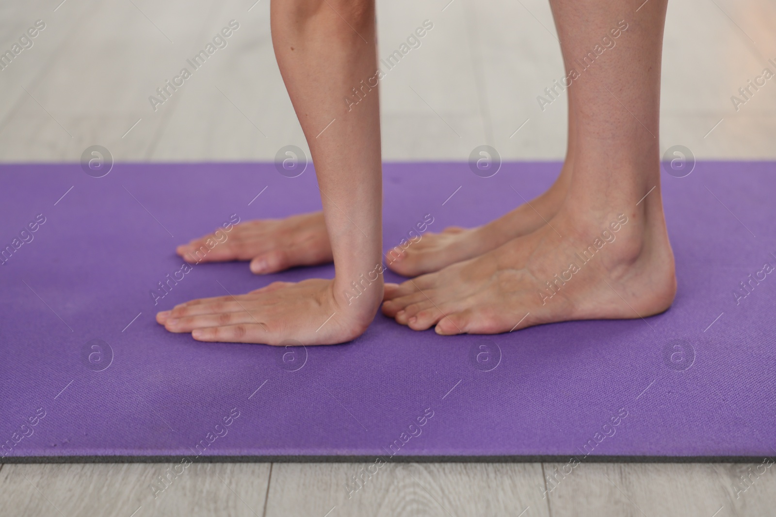 Woman stretching on mat at home, closeup Photo of Woman stretching on mat at home, closeup